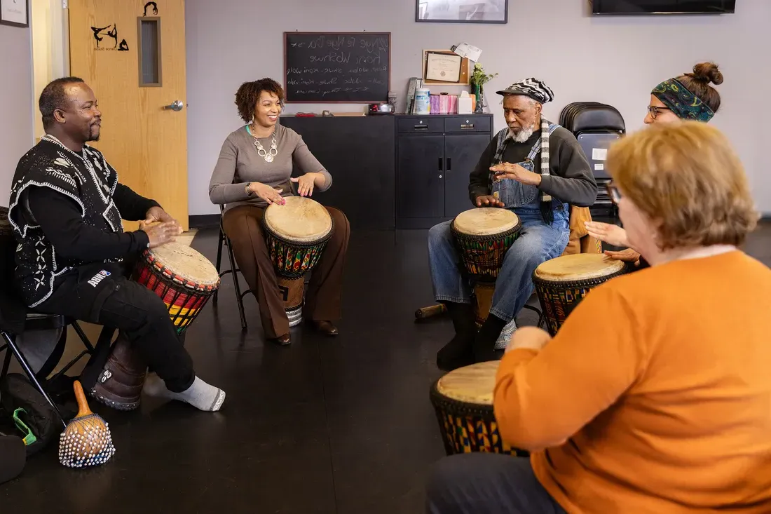 Tanisha Jackson, Assistant Professor of African American Studies and the Community Folk Art Center Executive Director, plays drums with others.